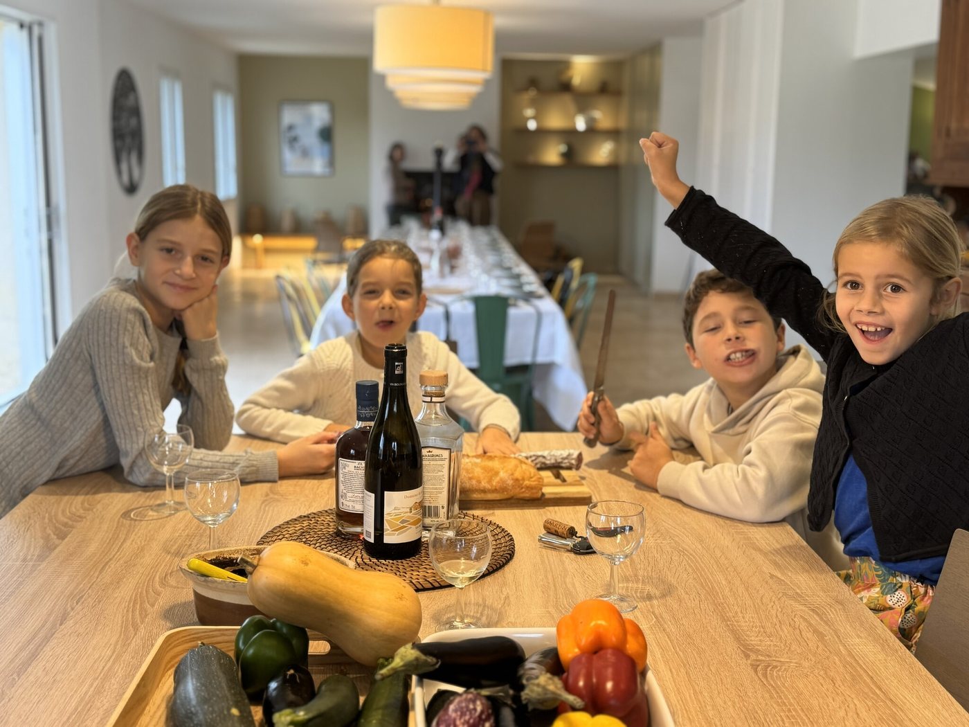 L'intérieur rénové de La Longère : l'îlot de cuisine et la grande table dressée